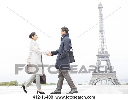 Stock Photo - Business people shaking hands near Eiffel Tower, Paris, France. Fotosearch