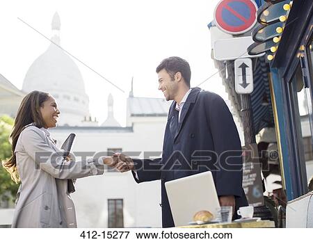 Stock Photo - Business people shaking hands on city street. Fotosearch