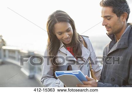 Stock Image - Business people using digital tablet outdoors. Fotosearch