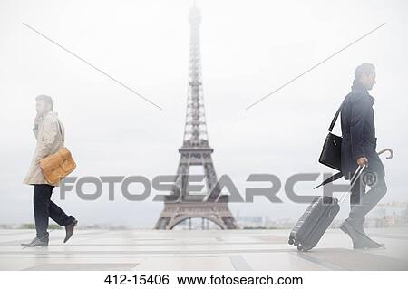 Stock Photograph - Business people walking past Eiffel Tower, Paris, France. Fotosearch