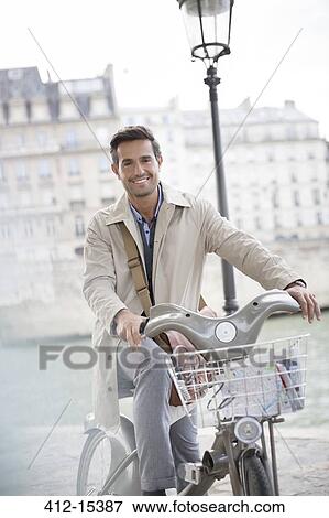 Businessman on bicycle along Seine River, Paris, France View Large Photo Image Stock Photo - Businessman on bicycle along Seine River, Paris, France. Fotosearch