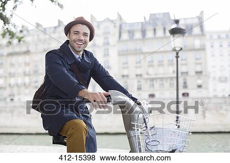 Businessman on bicycle along Seine River, Paris, France View Large Photo Image Stock Photo - Businessman on bicycle along Seine River, Paris, France. Fotosearch