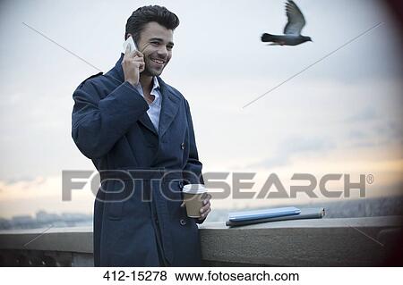 Stock Photo - Businessman on cell phone outdoors. Fotosearch