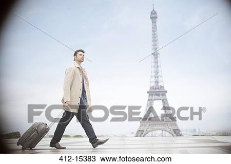 Businessman pulling suitcase near Eiffel Tower, Paris, France View Large Photo Image Stock Image - Businessman pulling suitcase near Eiffel Tower, Paris, France. Fotosearch
