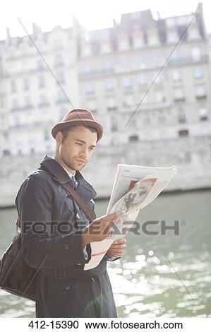 Businessman reading newspaper along Seine River, Paris, France View Large Photo Image Stock Image - Businessman reading newspaper along Seine River, Paris, France. Fotosearch