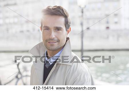 Picture - Businessman smiling along Seine River, Paris, France. Fotosearch