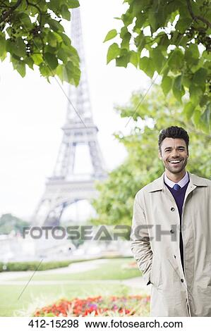 Stock Photo - Businessman smiling near Eiffel Tower, Paris, France. Fotosearch