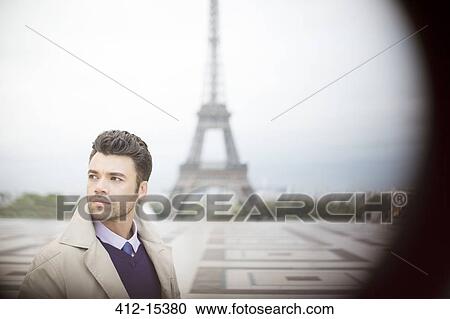 Stock Image - Businessman standing near Eiffel Tower, Paris, France. Fotosearch