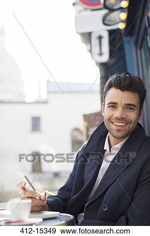 Businessman using cell phone at sidewalk cafe View Large Photo Image Stock Photo - Businessman using cell phone at sidewalk cafe. Fotosearch