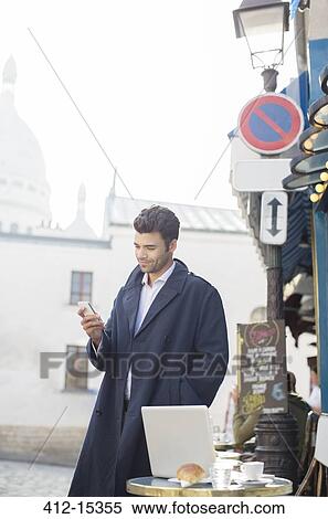 Businessman using cell phone at sidewalk cafe View Large Photo Image Stock Photography - Businessman using cell phone at sidewalk cafe. Fotosearch