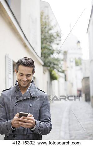 Businessman using cell phone on city street near Sacre Coeur Basilica, Paris, France View Large Photo Image Stock Image - Businessman using cell phone on city street near Sacre Coeur Basilica, Paris, France. Fotosearch