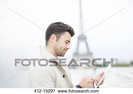 Businessman using digital tablet by Eiffel Tower, Paris, France View Large Photo Image Stock Photo - Businessman using digital tablet by Eiffel Tower, Paris, France. Fotosearch