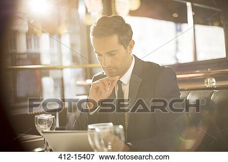 Businessman using digital tablet in restaurant View Large Photo Image Stock Photo - Businessman using digital tablet in restaurant. Fotosearch