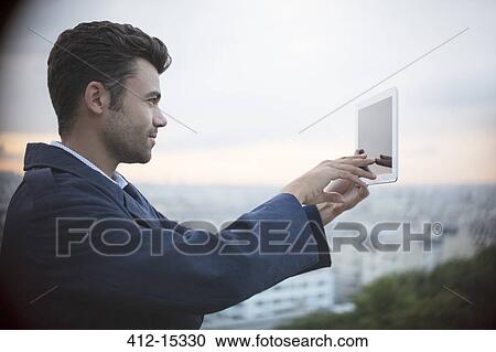 Businessman using digital tablet outdoors View Large Photo Image Stock Image - Businessman using digital tablet outdoors. Fotosearch
