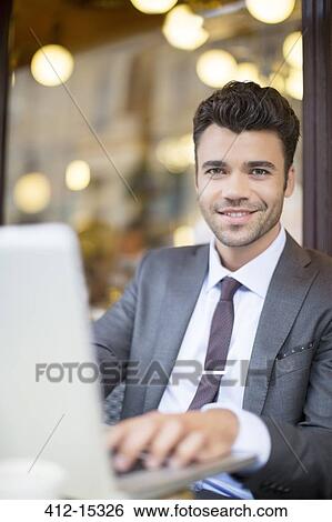 Businessman using laptop in sidewalk cafe View Large Photo Image Stock Photograph - Businessman using laptop in sidewalk cafe. Fotosearch