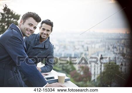 Businessmen smiling at railing overlooking Paris, France View Large Photo Image Picture - Businessmen smiling at railing overlooking Paris, France. Fotosearch