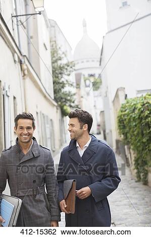 Stock Image - Businessmen walking on street near Sacre Coeur Basilica, Paris, France. Fotosearch
