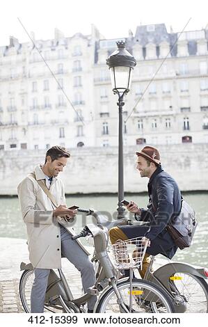 Businessmen with cell phones on bicycles along Seine River, Paris, France View Large Photo Image Stock Photo - Businessmen with cell phones on bicycles along Seine River, Paris, France. Fotosearch