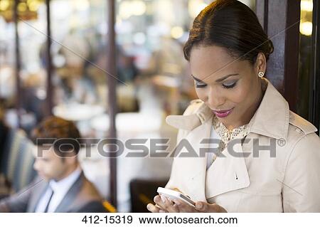 Businesswoman using cell phone at sidewalk cafe View Large Photo Image Stock Photo - Businesswoman using cell phone at sidewalk cafe. Fotosearch