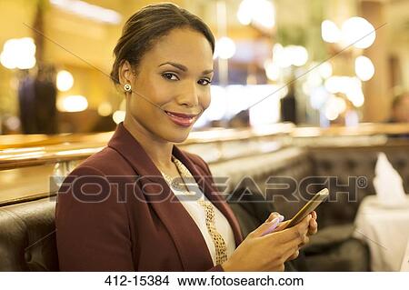 Businesswoman using cell phone in restaurant View Large Photo Image Picture - Businesswoman using cell phone in restaurant. Fotosearch