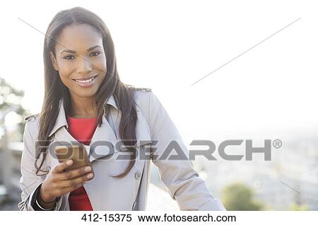 Businesswoman using cell phone outdoors View Large Photo Image Stock Photography - Businesswoman using cell phone outdoors. Fotosearch