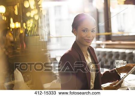 Businesswoman using digital tablet in restaurant View Large Photo Image Stock Image - Businesswoman using digital tablet in restaurant. Fotosearch