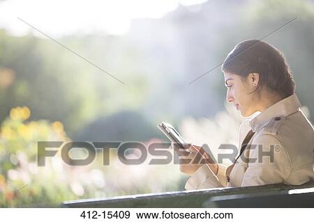 Stock Photo - Businesswoman using digital tablet in park. Fotosearch