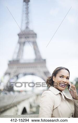 Woman talking on cell phone by Eiffel Tower, Paris, France View Large Photo Image Picture - Woman talking on cell phone by Eiffel Tower, Paris, France. Fotosearch