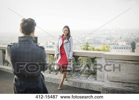 Stock Photo - Boyfriend photographing girlfriend with Paris in background. Fotosearch