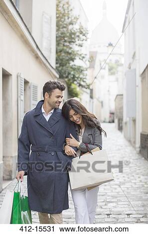 Couple carrying shopping bags on cobblestone street near Sacre Coeur Basilica, Paris, France View Large Photo Image Stock Image - Couple carrying shopping bags on cobblestone street near Sacre Coeur Basilica, Paris, France. Fotosearch