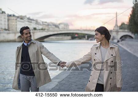 Couple holding hands along Seine River, Paris, France View Large Photo Image Stock Image - Couple holding hands along Seine River, Paris, France. Fotosearch