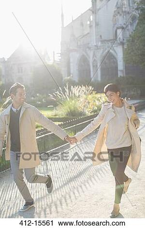 Couple holding hands in urban park View Large Photo Image Stock Image - Couple holding hands in urban park. Fotosearch