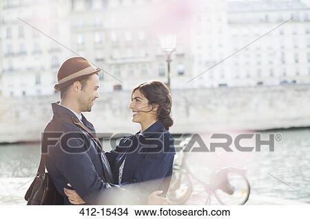 Picture - Couple hugging along Seine River, Paris, France. Fotosearch