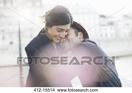 Picture - Couple hugging along Seine River, Paris, France. Fotosearch