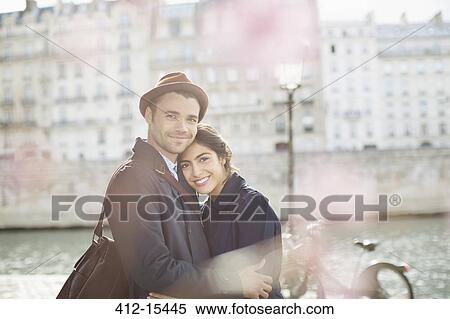 Stock Photography - Couple hugging along Seine River, Paris, France. Fotosearch