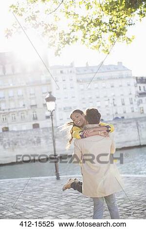 Stock Photography - Couple hugging along Seine River, Paris, France. Fotosearch