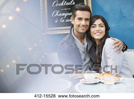 Stock Photo - Couple hugging at sidewalk cafe in Paris, France. Fotosearch
