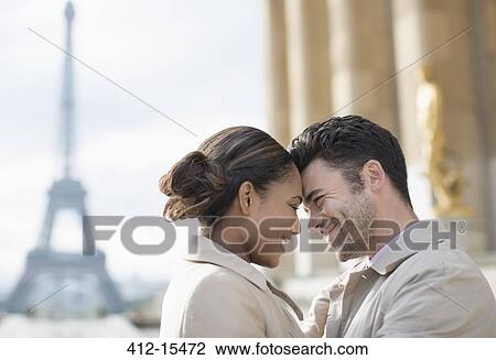 Stock Image - Couple hugging in front of Eiffel Tower, Paris, France. Fotosearch