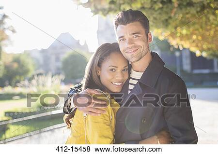 Stock Photo - Couple hugging in urban park. Fotosearch