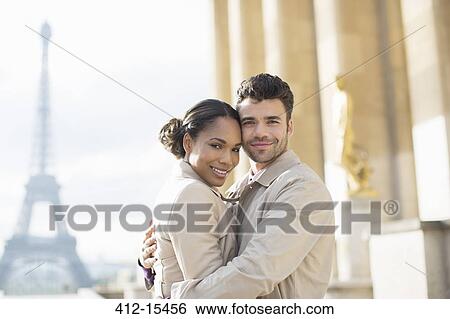 Stock Photograph - Couple hugging near Eiffel Tower, Paris, France. Fotosearch