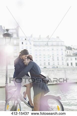 Couple hugging on bicycle along Seine River, Paris, France View Large Photo Image Stock Photo - Couple hugging on bicycle along Seine River, Paris, France. Fotosearch