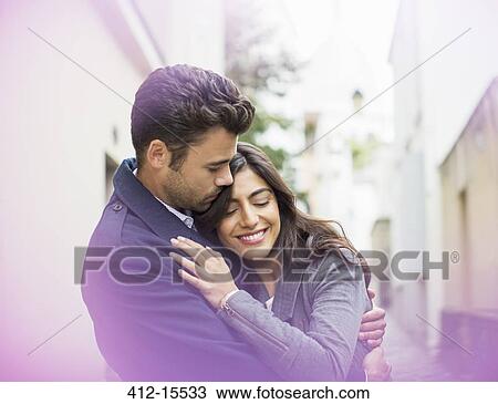 Stock Image - Couple hugging outdoors. Fotosearch