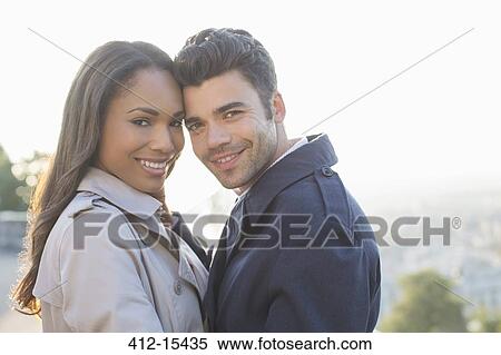 Stock Photography - Couple in trench coats hugging. Fotosearch