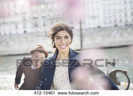 Couple laughing and running along Seine River, Paris, France View Large Photo Image Stock Image - Couple laughing and running along Seine River, Paris, France. Fotosearch