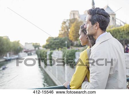 Stock Photograph - Couple looking at Seine River, Paris, France. Fotosearch