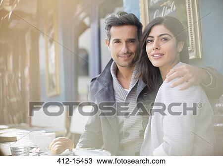 Stock Image - Couple sitting together at sidewalk cafe. Fotosearch
