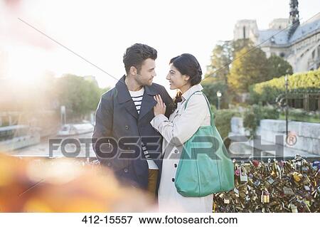 Stock Photo - Couple standing on Pont des Arts bridge over Seine River, Paris, France. Fotosearch