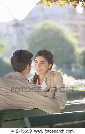 Stock Photo - Couple talking on park bench. Fotosearch