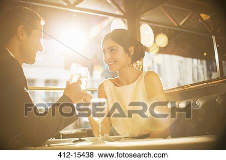 Stock Photo - Couple toasting champagne flutes in restaurant. Fotosearch
