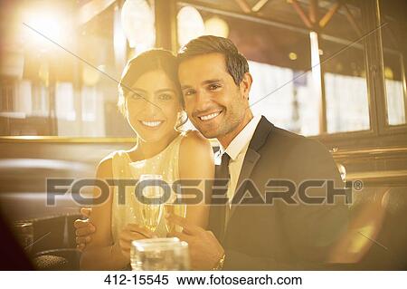 Couple toasting champagne flutes in restaurant View Large Photo Image Stock Photography - Couple toasting champagne flutes in restaurant. Fotosearch